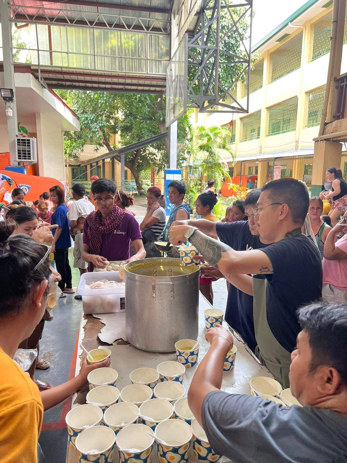 Serving bowls of lugaw to feed the hungry evacuees.